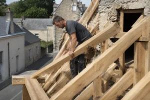 Artisan posant les poutres en bois d'une charpente et toiture sur un chantier de rénovation